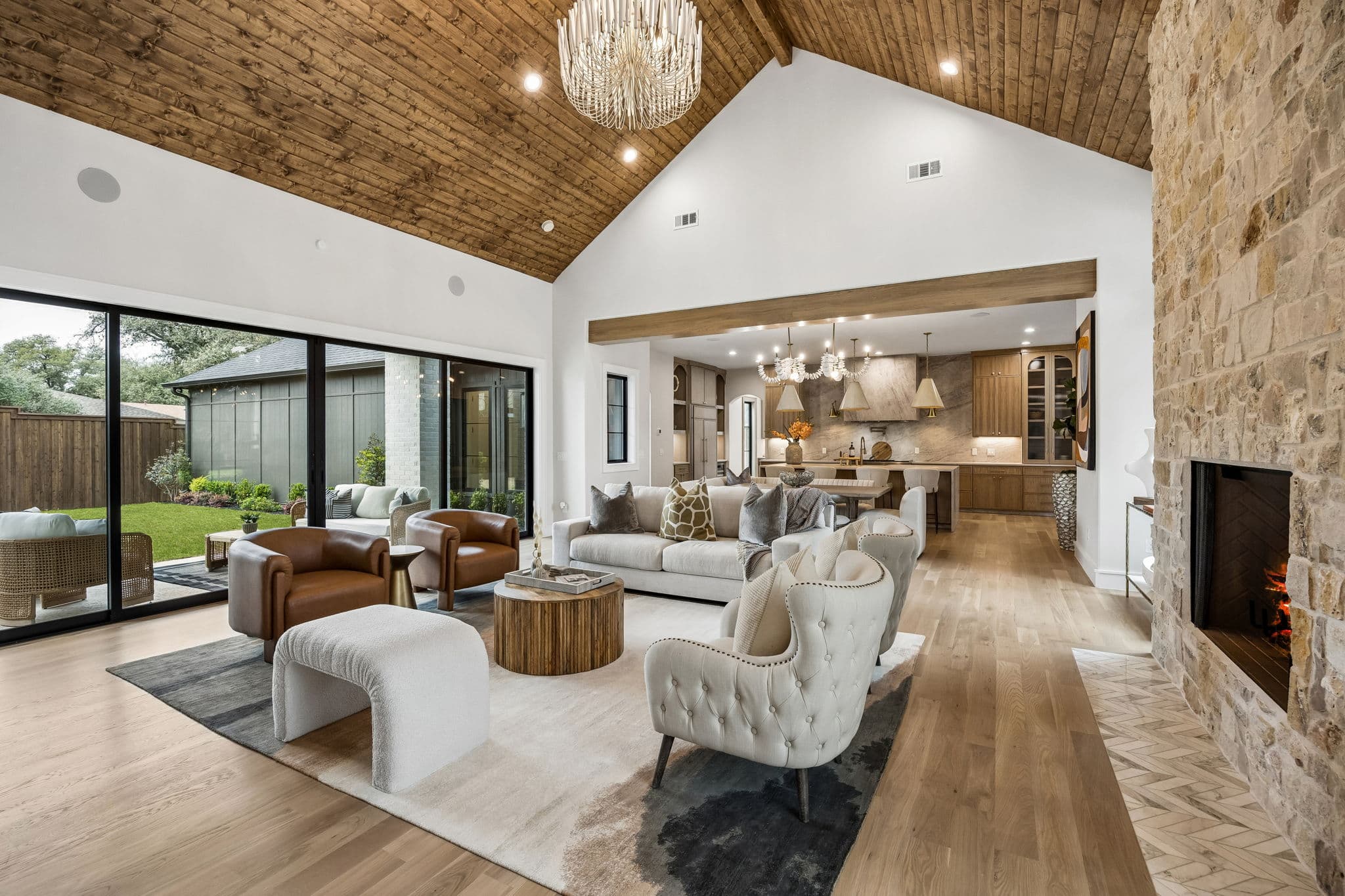 Living room at 7272 Tangleglen under a vaulted plank ceiling, glass doors along one wall.