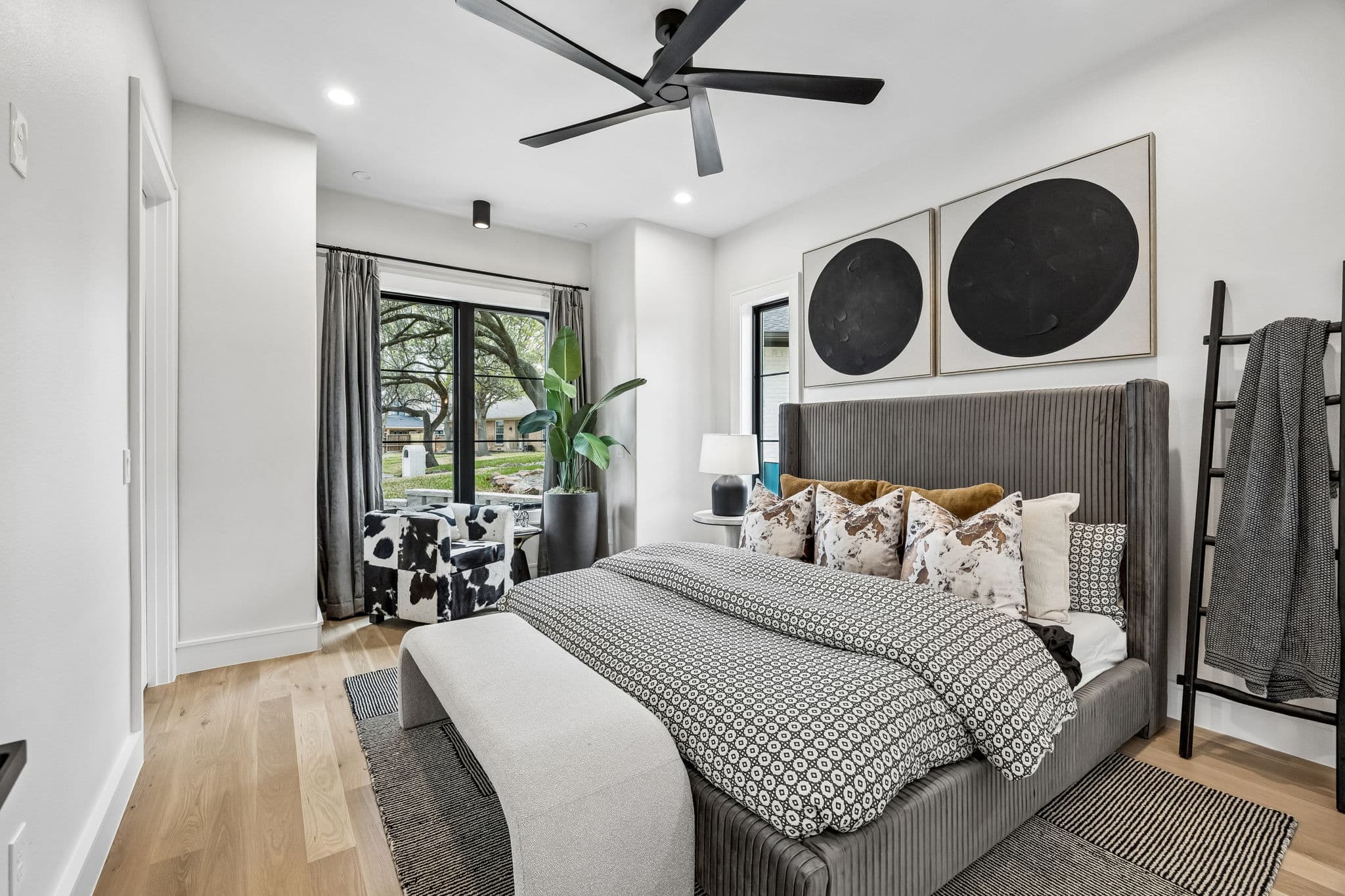 A bedroom at 7272 Tangleglen, a four poster under a ceiling fan with framed prints above the bed.