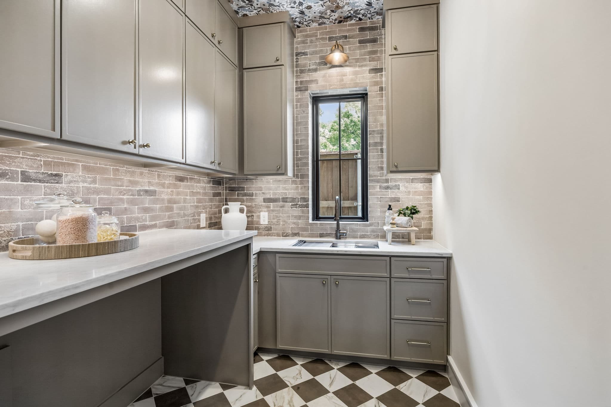 The laundry at 7308 Tangleglen, a checkerboard floor under a run of counter and cabinetry.