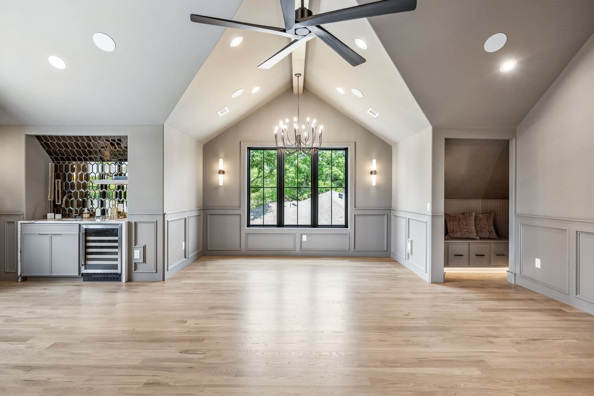 The game room at 7308 Tangleglen, a vaulted ceiling with exposed beams over an open floor and a bar at one end.