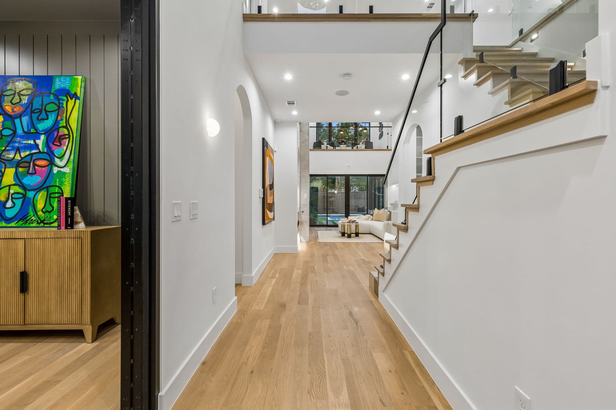 The entry hall at 7615 Morton, oak floors running past the stair to the rooms beyond.