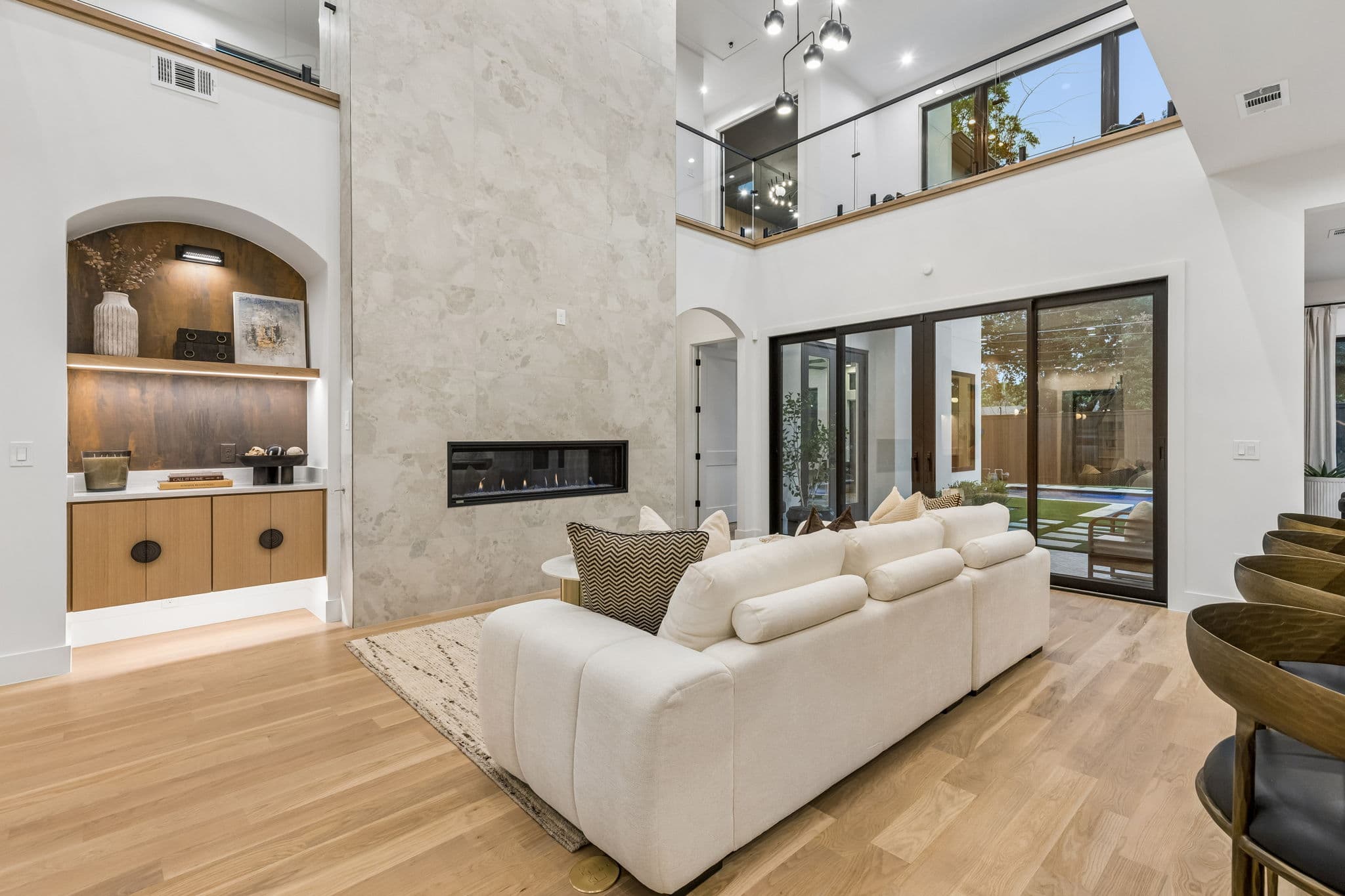 The living room at 7615 Morton from the far end, a balcony above and glazed doors onto the garden.