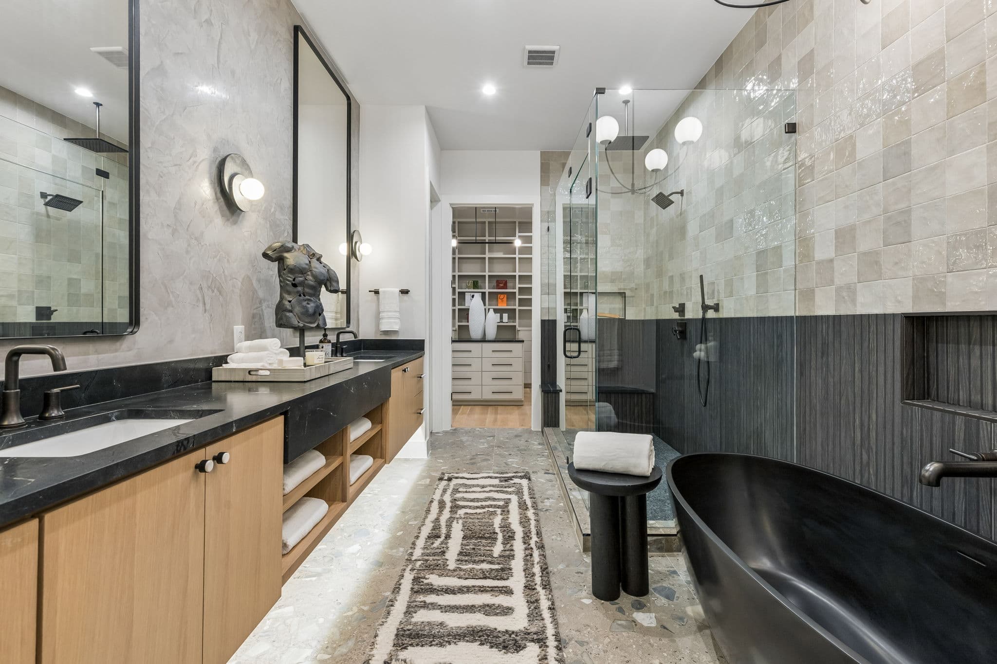 The primary bath at 7615 Morton, a black freestanding tub at the end of a long vanity.