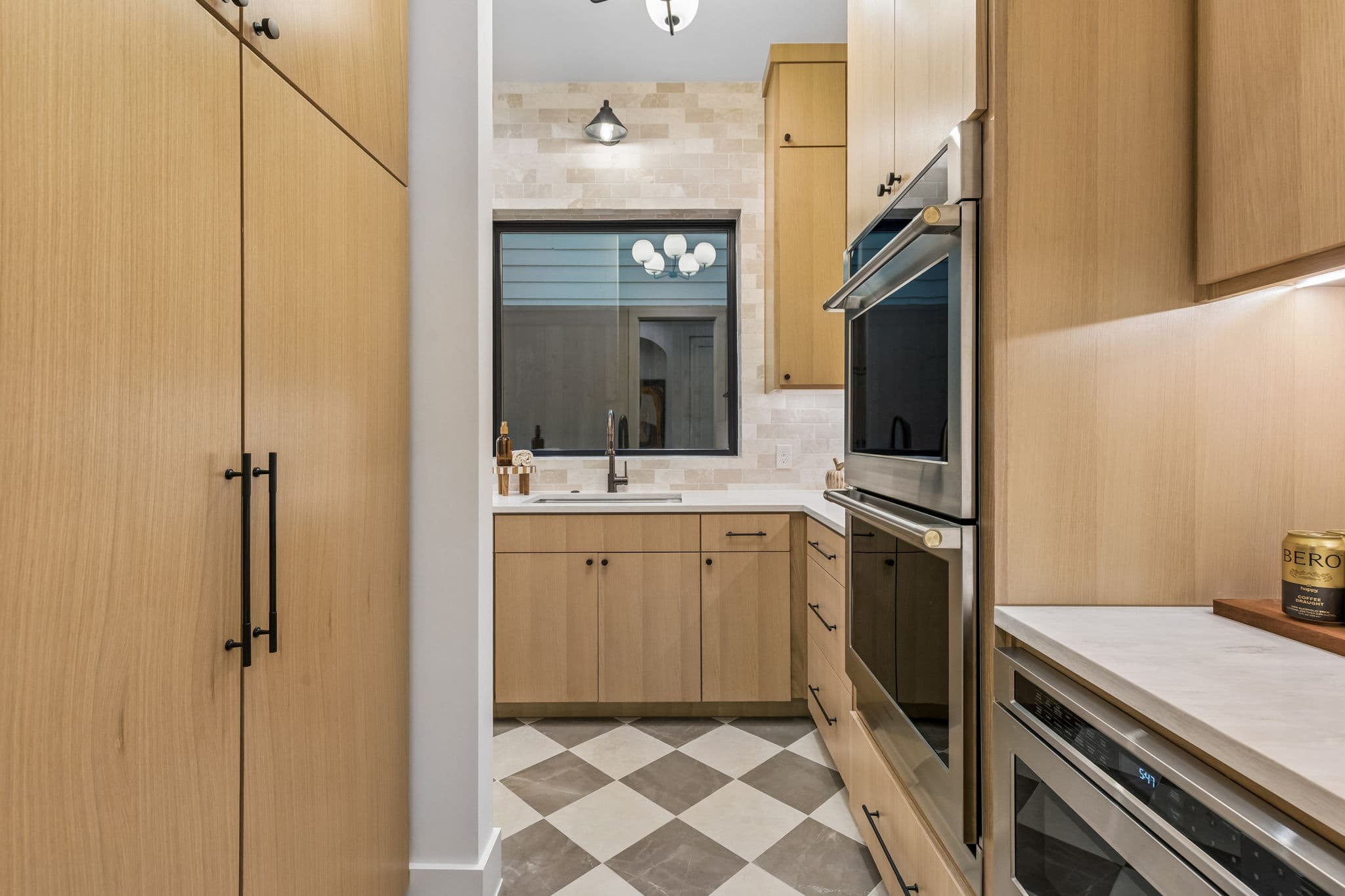 The butler's pantry at 7615 Morton, a checkerboard floor between runs of cabinetry.
