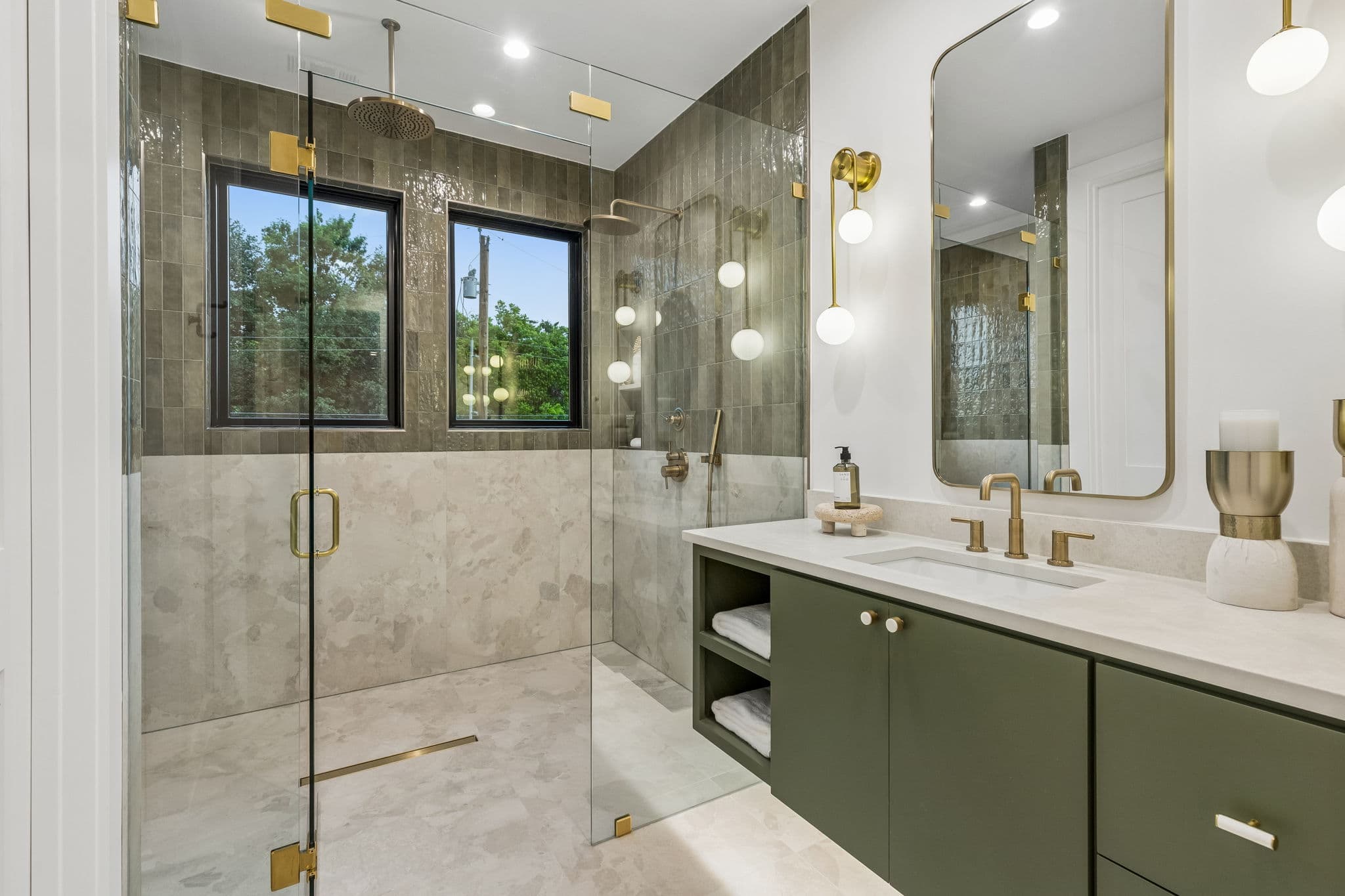 A bath at 7615 Morton, a glazed shower beside an olive vanity under twin mirrors.