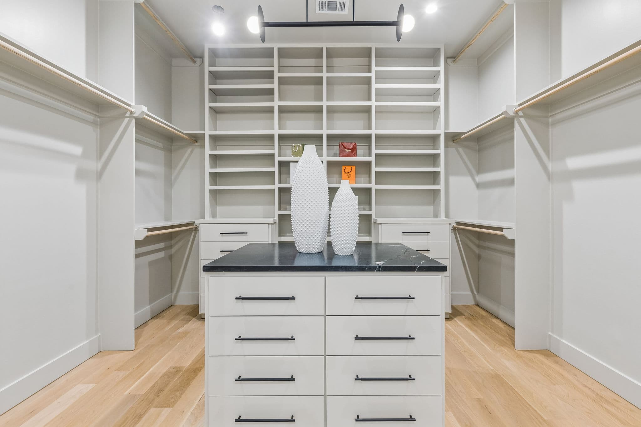 The dressing room at 7615 Morton, white built in shelving around a fitted island.