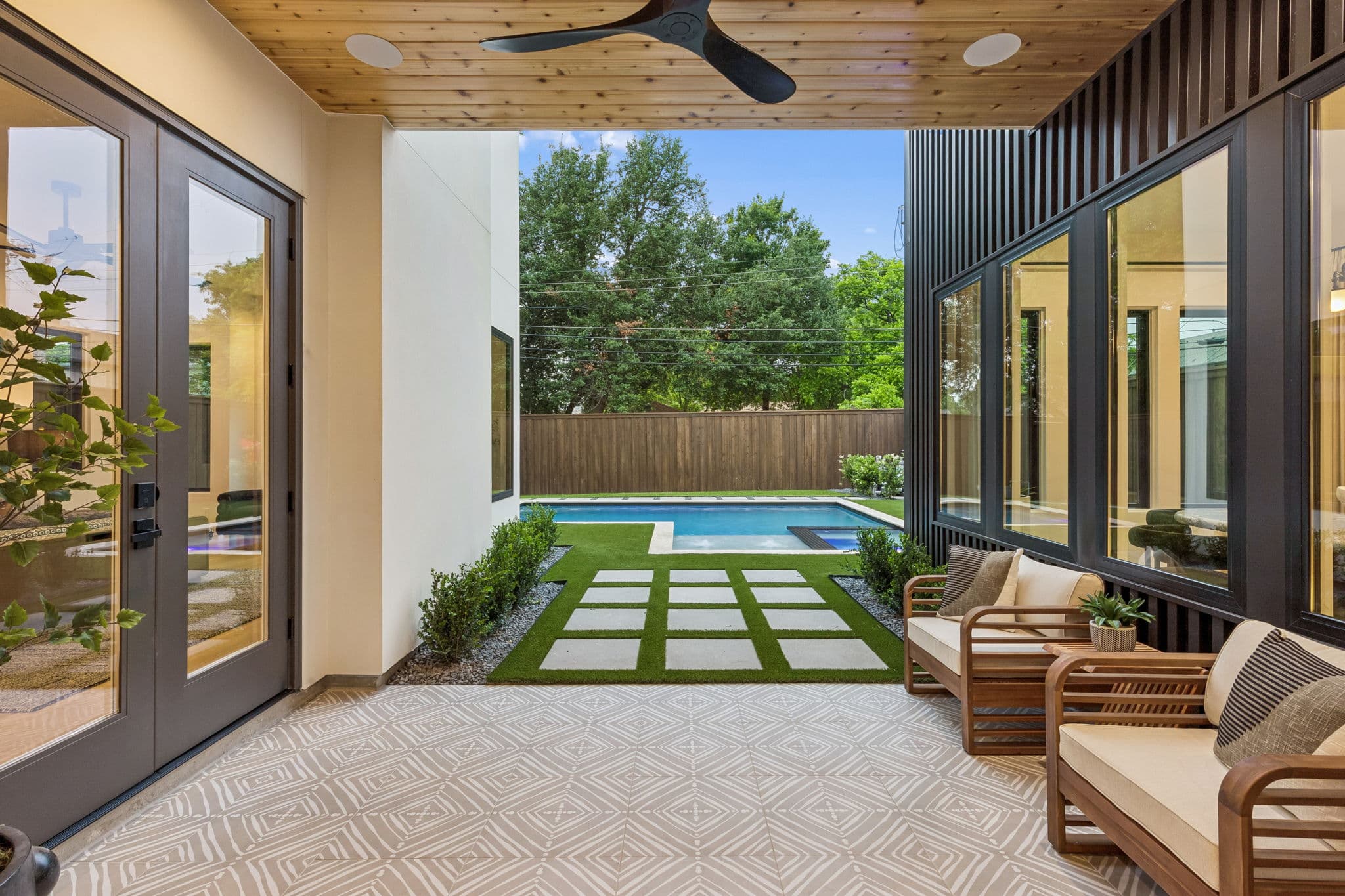 The courtyard at 7615 Morton seen from inside, doors opening onto pavers and planting.