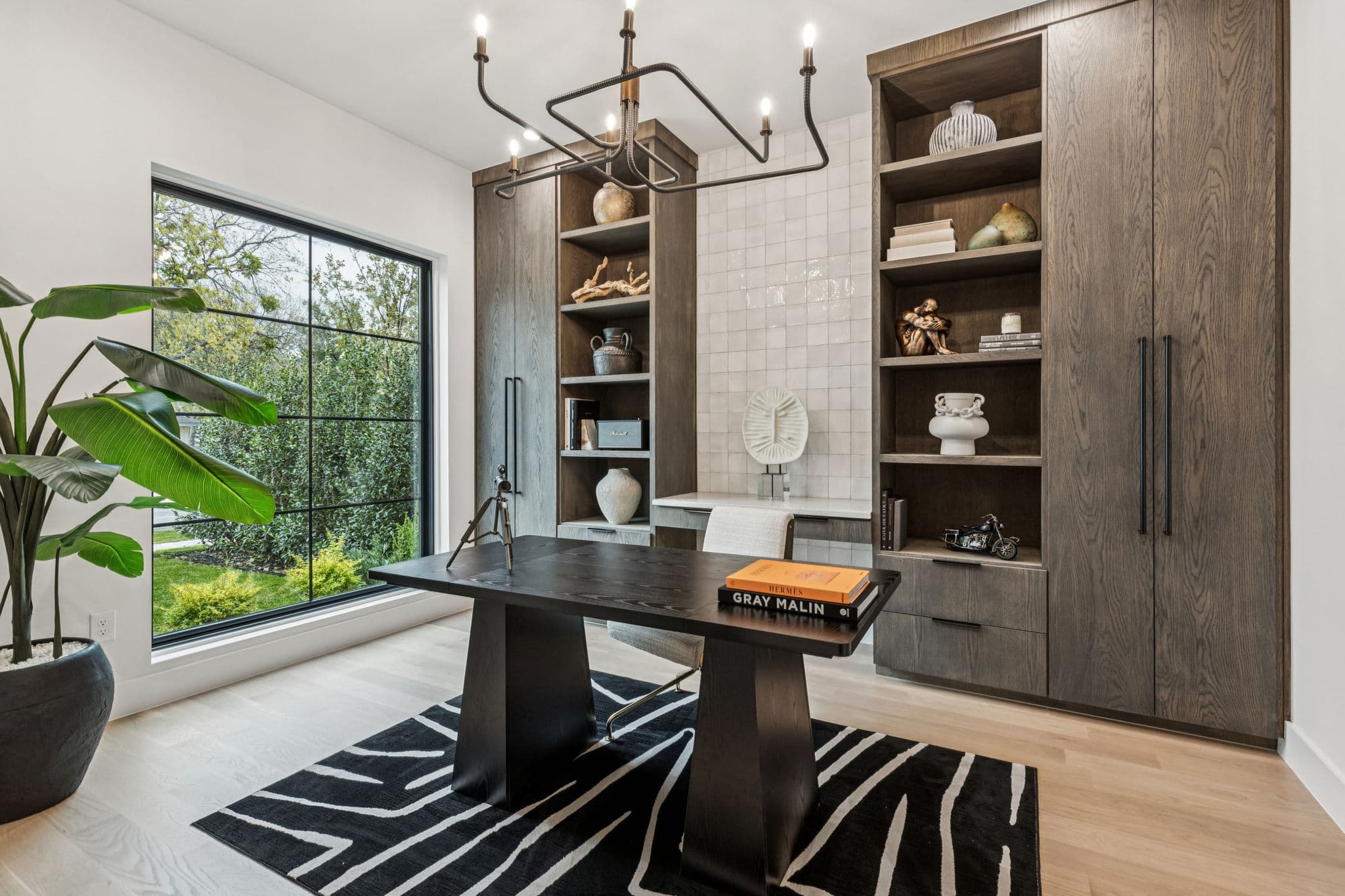 The dining room at 7707 Robin Road, a dark table under a chandelier with open shelving along the wall.