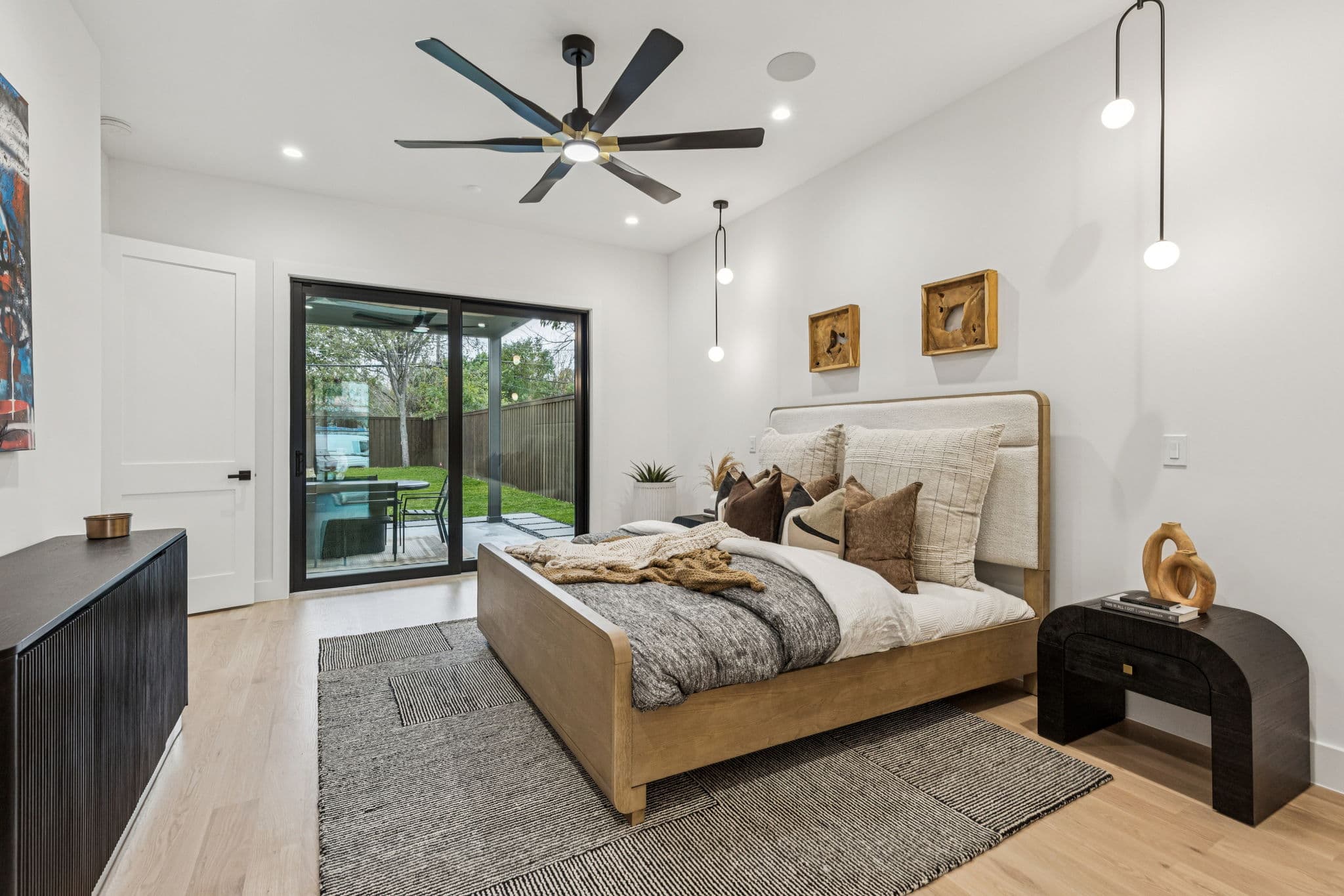 A bedroom at 7707 Robin Road, a low bed between windows with art on the wall beside it.