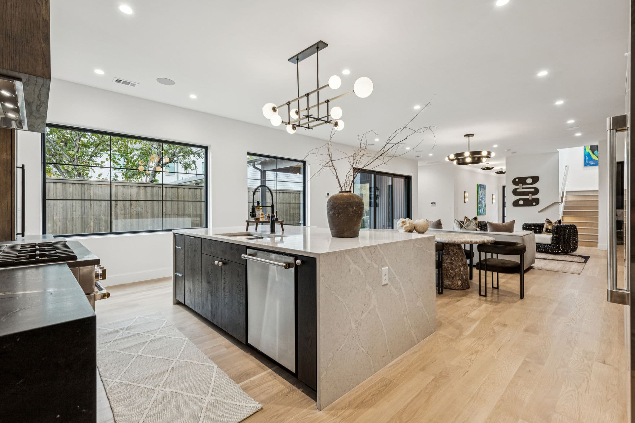 The kitchen at 7707 Robin Road, a stone island under pendants with dark cabinetry behind.